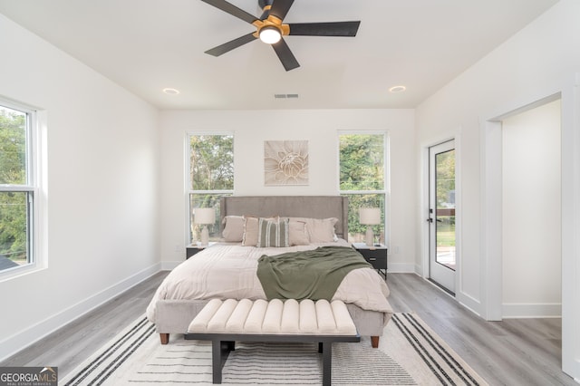 bedroom featuring multiple windows, access to exterior, and ceiling fan