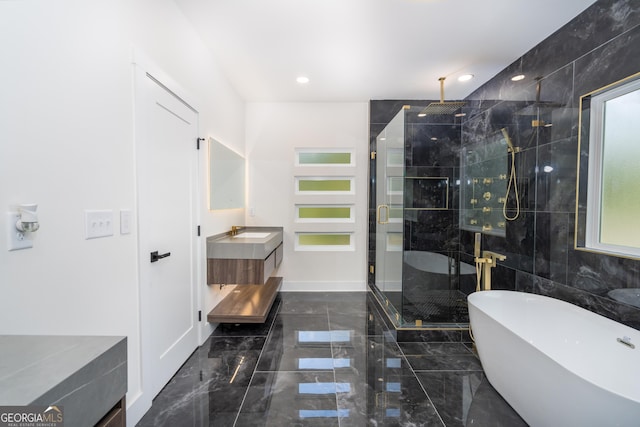 bathroom with tile walls, vanity, and shower with separate bathtub