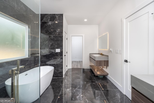 bathroom with vanity, tile walls, and a bathtub