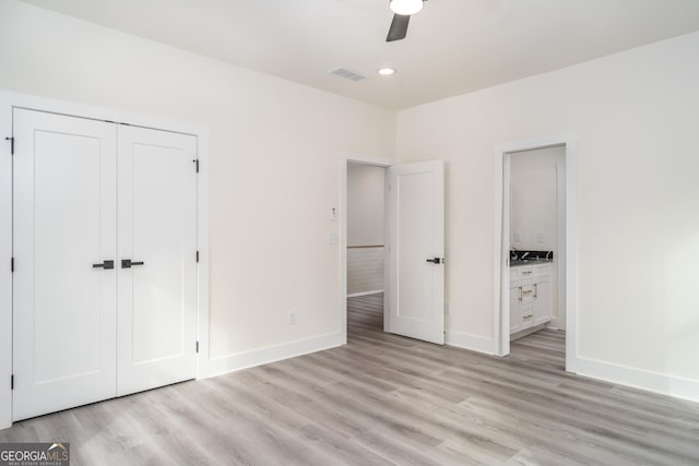 unfurnished bedroom featuring ceiling fan, light hardwood / wood-style flooring, and a closet