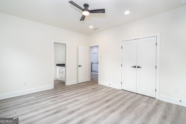 unfurnished bedroom with light wood-type flooring, ceiling fan, and a closet