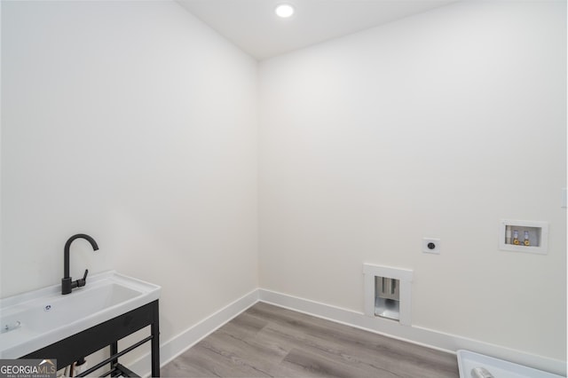 clothes washing area featuring washer hookup, hookup for an electric dryer, light hardwood / wood-style floors, and sink