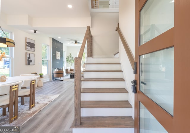 staircase featuring ceiling fan and wood-type flooring