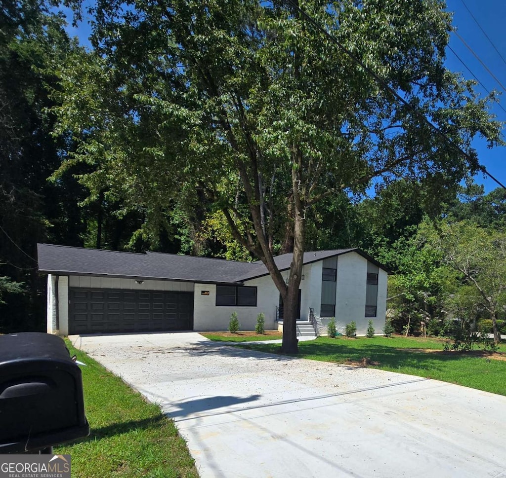 view of front of property featuring a front yard and a garage