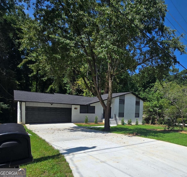 view of front of property featuring a front yard and a garage