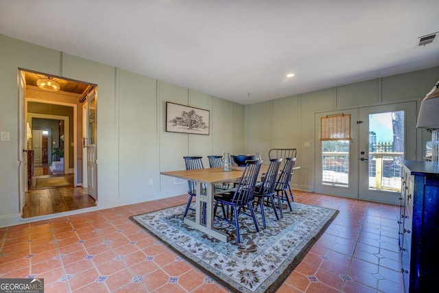 dining space with tile patterned flooring and french doors