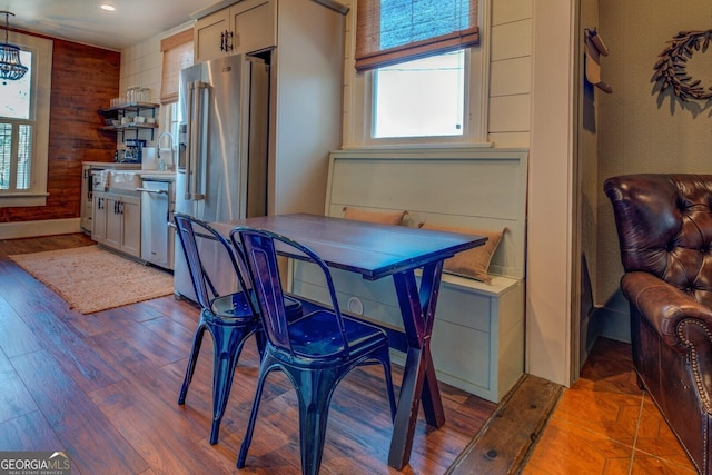 dining area featuring wooden walls and wood-type flooring