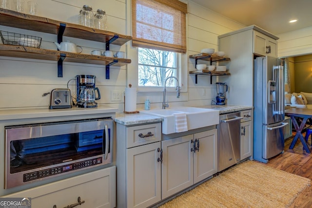 kitchen featuring gray cabinets, appliances with stainless steel finishes, sink, light hardwood / wood-style flooring, and tasteful backsplash