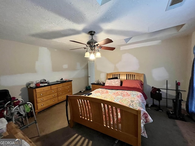 bedroom featuring a textured ceiling, ceiling fan, and dark carpet