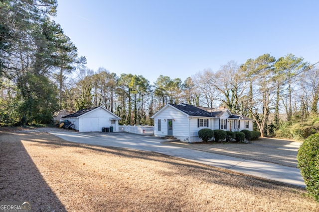 view of front of house featuring a garage and an outbuilding