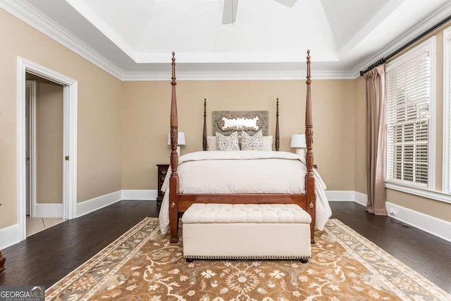 bedroom featuring ornamental molding, ceiling fan, a tray ceiling, and dark hardwood / wood-style floors