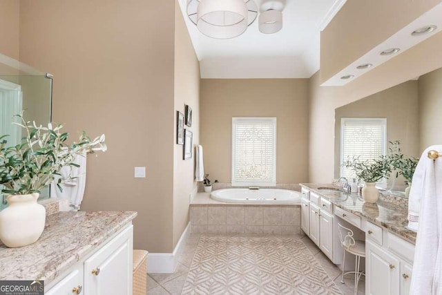 bathroom featuring a relaxing tiled tub, tile patterned flooring, and vanity