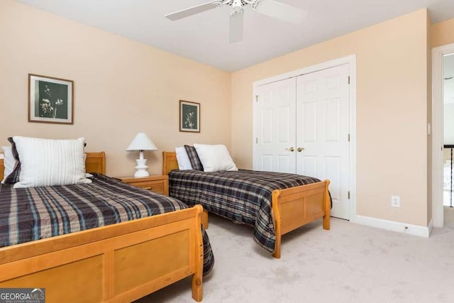 bedroom featuring ceiling fan, light colored carpet, and a closet