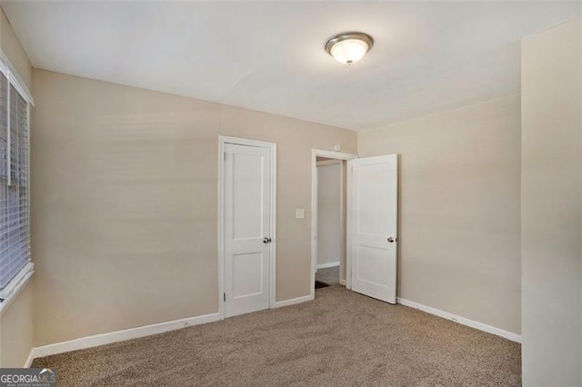 unfurnished bedroom featuring light colored carpet and a closet