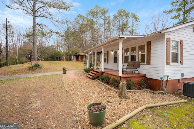 view of side of property featuring a porch and cooling unit