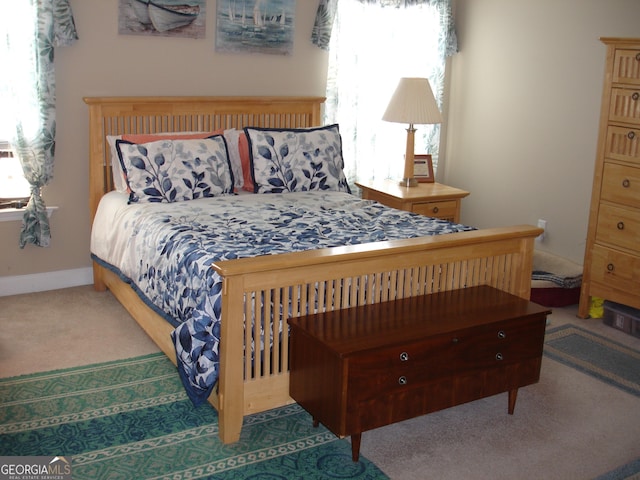 carpeted bedroom featuring multiple windows and baseboards