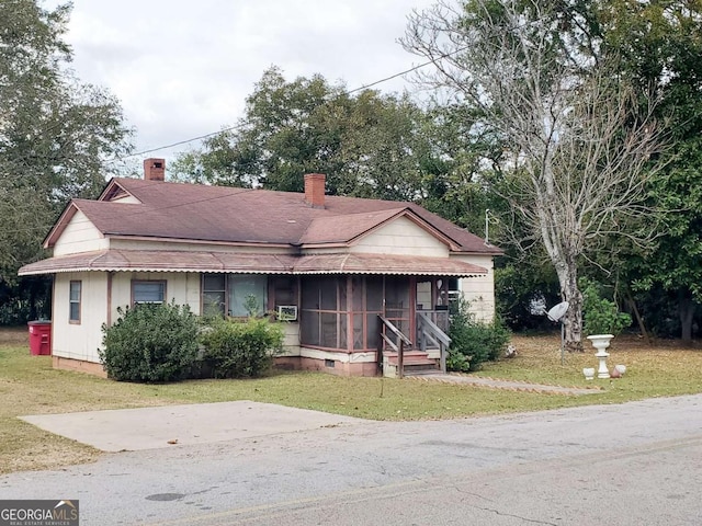 view of front of property with a sunroom and a front yard