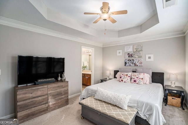 bedroom featuring connected bathroom, light carpet, ornamental molding, a raised ceiling, and ceiling fan