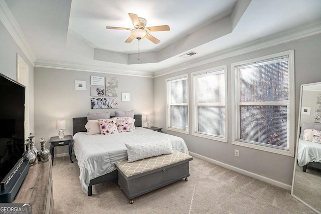 carpeted bedroom featuring crown molding, ceiling fan, and a tray ceiling