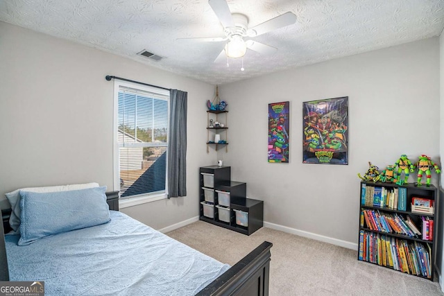 carpeted bedroom featuring a textured ceiling and ceiling fan