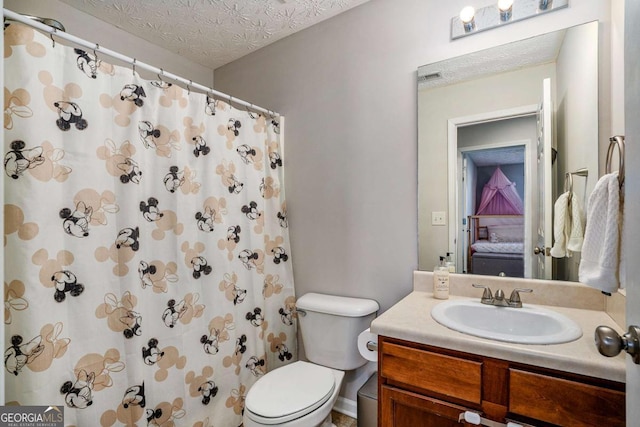 bathroom with vanity, curtained shower, toilet, and a textured ceiling