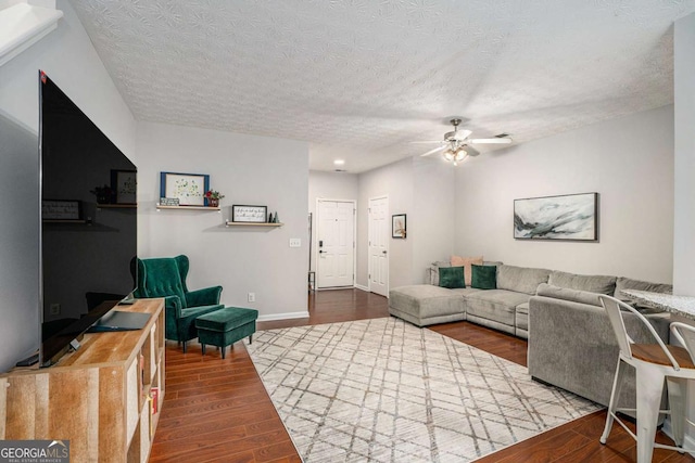 living room featuring ceiling fan, hardwood / wood-style floors, and a textured ceiling