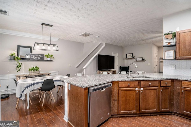 kitchen featuring pendant lighting, dishwasher, sink, light stone counters, and a textured ceiling