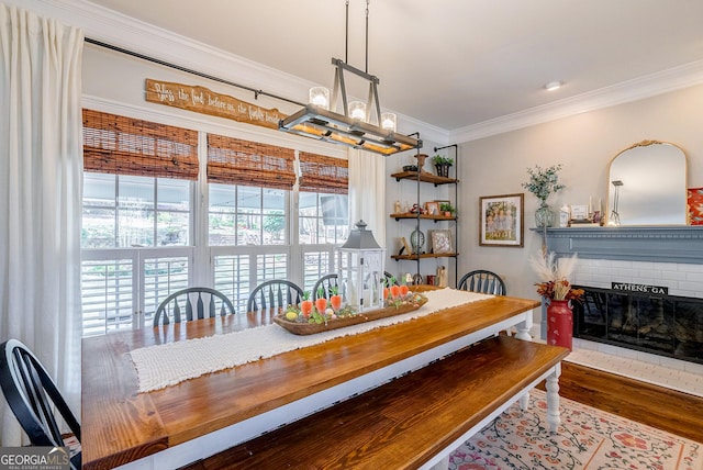 1231 Scarlet Oak Cir, Athens, GA 30606 - dining area with crown molding, wood finished floors, a chandelier, and a brick fireplace