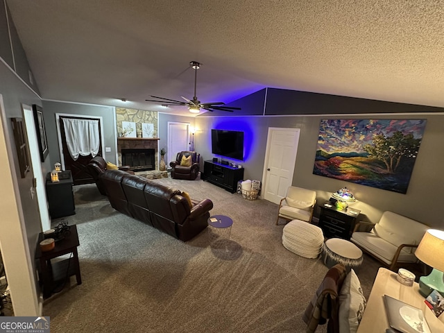 carpeted living room with ceiling fan, vaulted ceiling, a textured ceiling, and a fireplace