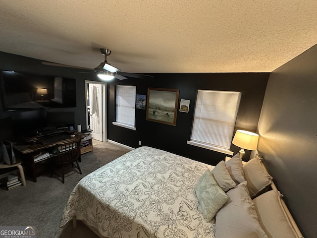 bedroom with a textured ceiling, ceiling fan, and dark carpet