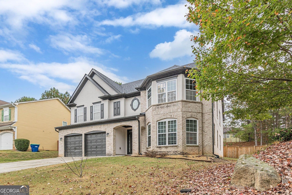 view of front of property featuring an attached garage, brick siding, fence, concrete driveway, and a front yard