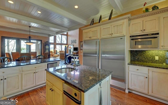 kitchen with stainless steel appliances, beam ceiling, light hardwood / wood-style floors, and sink