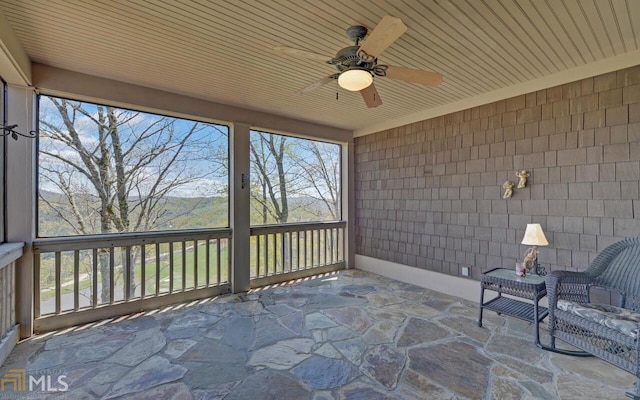 unfurnished sunroom featuring wood ceiling and ceiling fan