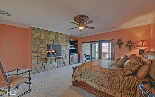 bedroom with a stone fireplace, crown molding, access to outside, carpet flooring, and ceiling fan