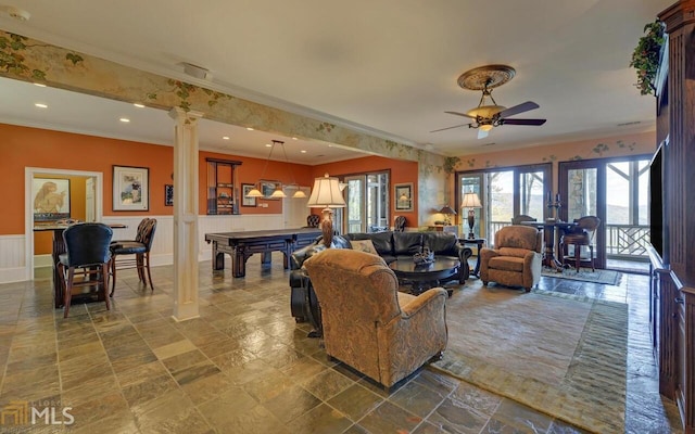 living room with crown molding, ceiling fan, and ornate columns