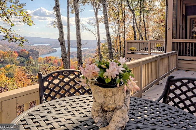 wooden terrace with a water and mountain view