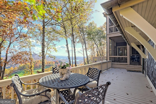 wooden deck with a mountain view and a sunroom