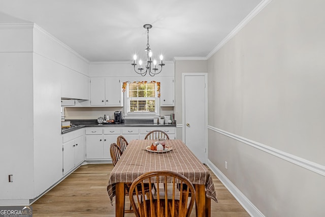 kitchen featuring ornamental molding, white cabinets, a chandelier, and light hardwood / wood-style flooring