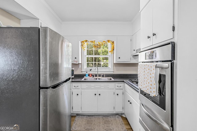 kitchen with crown molding, appliances with stainless steel finishes, sink, and white cabinets