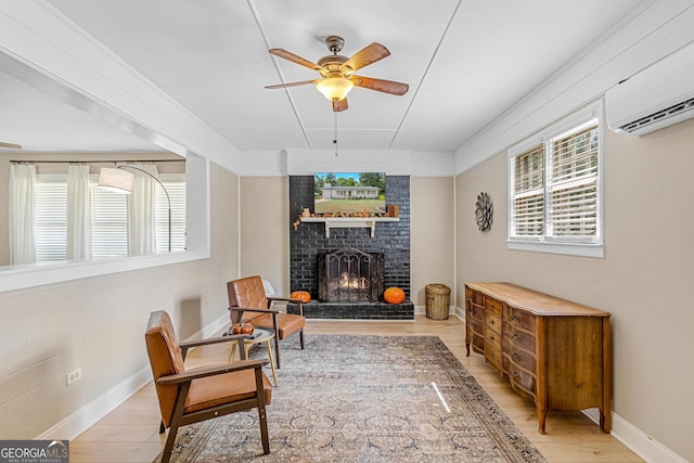 sitting room with ceiling fan, a fireplace, and light hardwood / wood-style floors