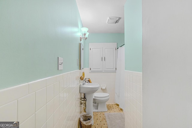 bathroom featuring tile walls, sink, tile patterned flooring, and toilet