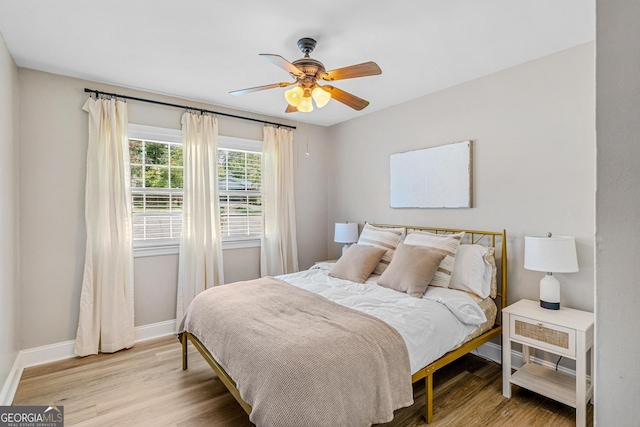 bedroom with light hardwood / wood-style flooring and ceiling fan