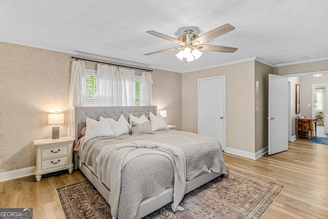 bedroom featuring ceiling fan, ornamental molding, light hardwood / wood-style flooring, and a textured ceiling