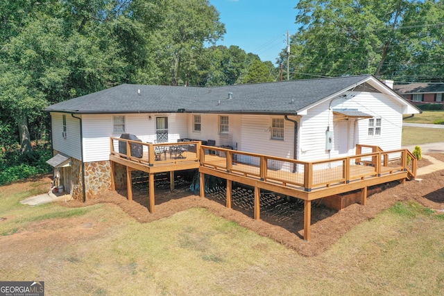 rear view of property featuring a wooden deck and a yard