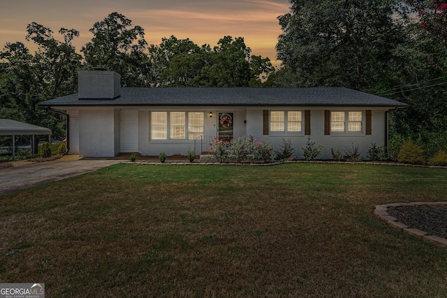 single story home featuring a carport and a lawn