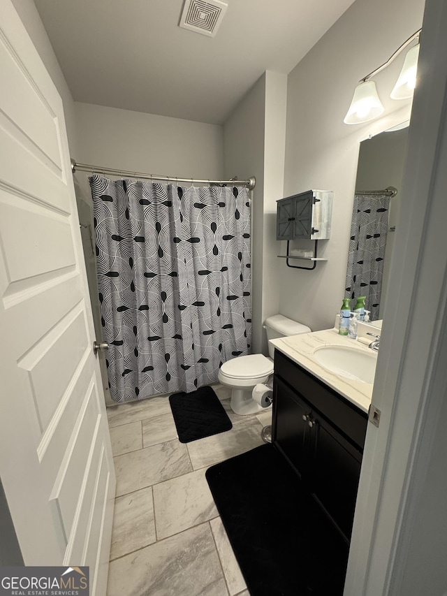 bathroom with toilet, vanity, and curtained shower