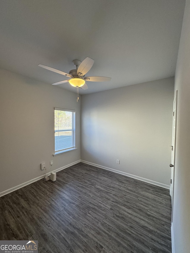 empty room featuring dark wood-type flooring and ceiling fan