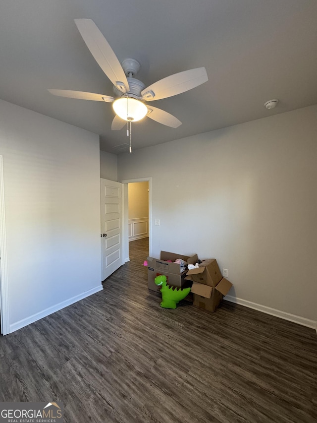 unfurnished room with ceiling fan and dark wood-type flooring