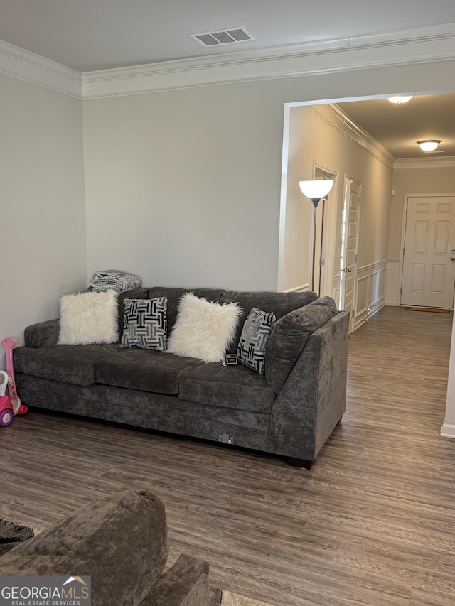 living room with wood-type flooring and crown molding