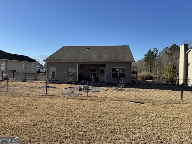 rear view of property featuring a lawn